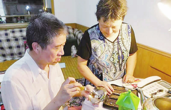 /郑献明正在家里挑灯夜战为邻居修理小家电