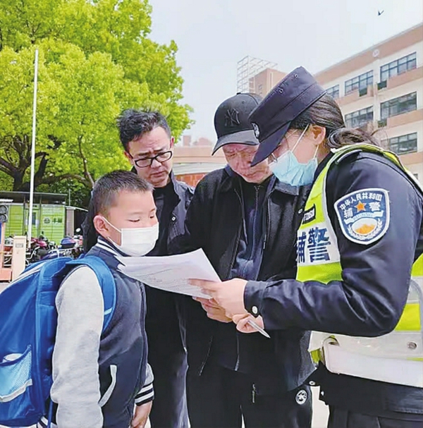 徐汇交通辅警蔡佩文在盛大花园小学门口收集家长对校园周边交通管理的意见