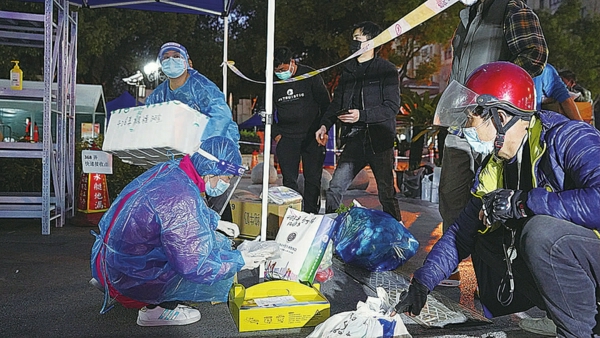 物流组工作人员在门口接收快递与外卖