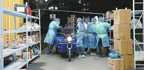 物流组工作人员分拣快递与外卖