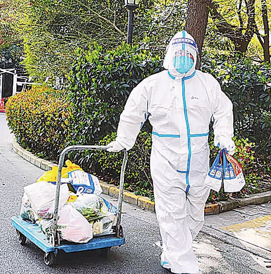 物流组工作人员拉着平板车运送快递与外卖