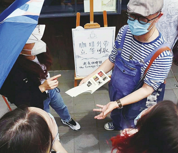 老麦向顾客介绍自己的手绘本