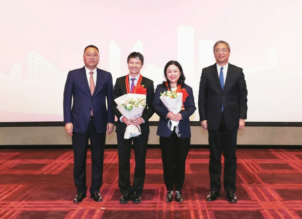 /市总工会主席莫负春(右一)、区委书记曹立强(左一)为全国五一劳动奖章刘伟、全国五一巾帼标兵宓莹颁奖