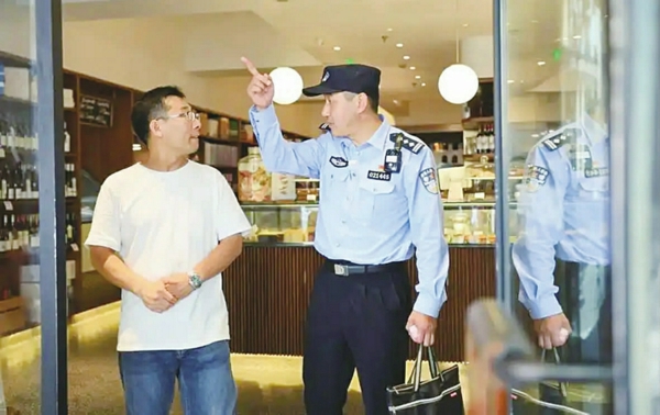 吴笔刚(右)在商户店内调解