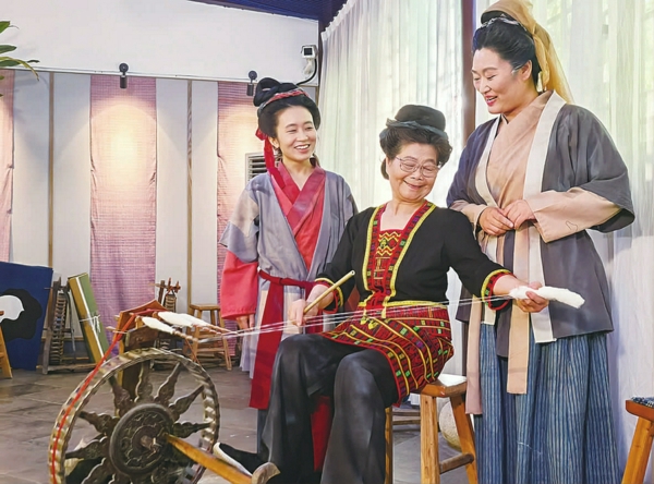 图为剧中的青年黄道婆(左)、中老年黄道婆(右)与黎族大妈(中)交流纺织技艺 陆翔 摄