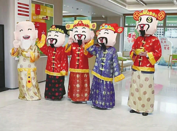 /工作人员扮演的五福人偶在门口迎接大家